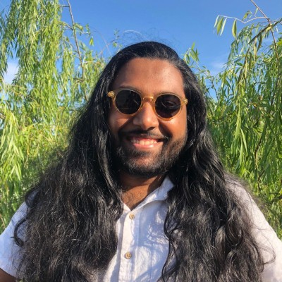 I am grinning at the camera as the bright sun shines on my curly locks